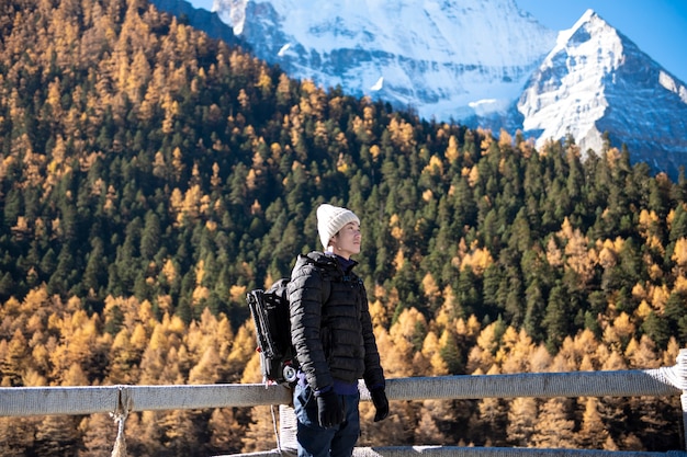 A hiking man is enjoying  in snow peak mountain at autumn, People traveling concept