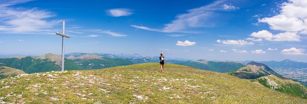 モンテラーゴ高原でのハイキングマルケイタリア緑の風景の中を歩く女性ユニークな丘と山の風景夏のアウトドアアクティビティ