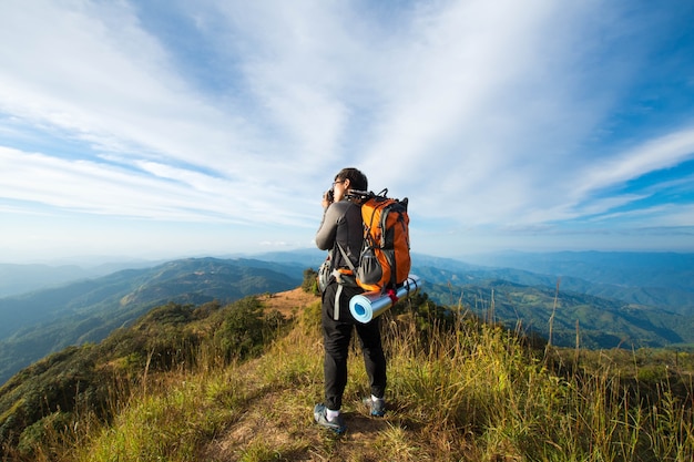 森林のハイキング人はトップ山に行く