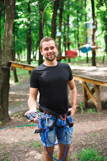 Hiking in the rope park young man in safe gear.