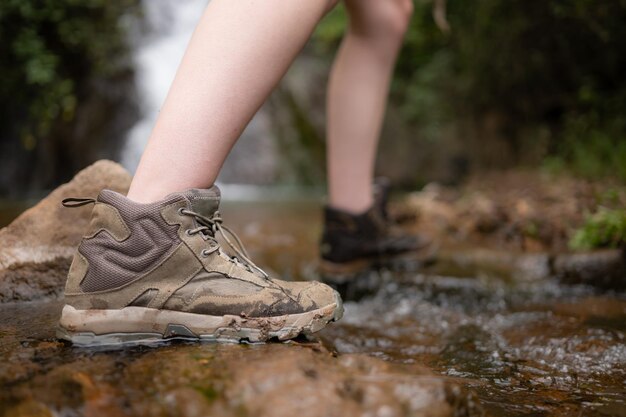 Foto scarpe da escursione su un tronco o su rocce nella foresta