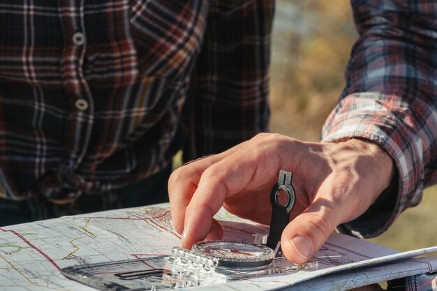 Hiking toerisme hobby close-up van mannenhand met kompas en kaart