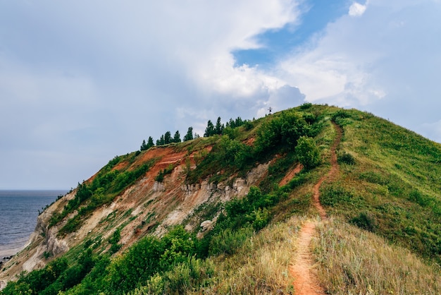 Hiking trail on mountainside at summer cloudy day