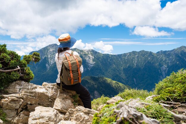 Photo hiking woman sit on the rock over the peak in east peak of hehuanshan