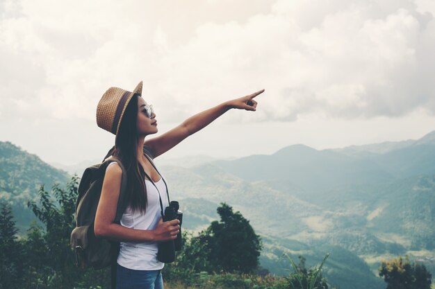 Hiking young woman with binoculars, Hiking concept.