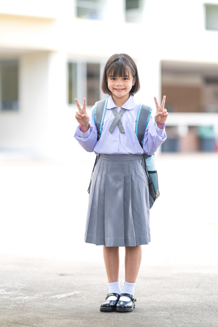 학교로 돌아가는 카메라를 바라보는 제복을 입은 힐드렌 학생