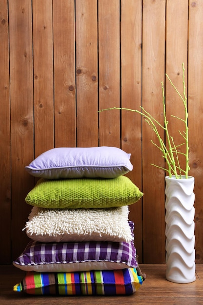 Hill of colorful pillows on rustic wooden background