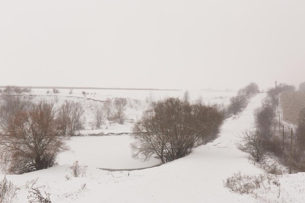 Photo hills near a snowy lake and a road in winter