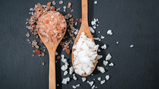 Photo himalaya pink salt crystal and sea salt crystal in wooden spoon
