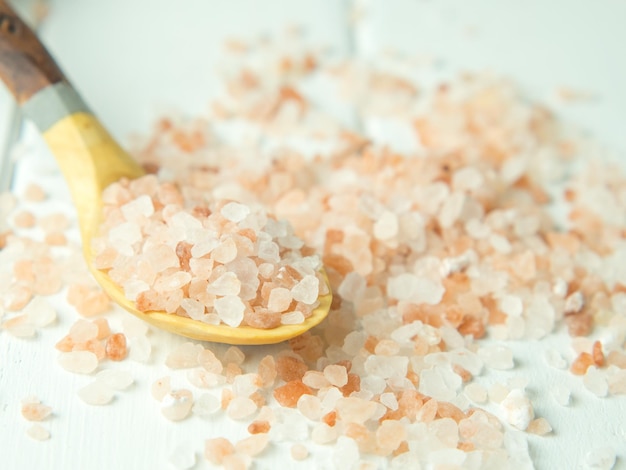 Himalayan pink salt in crystals scattered on a wooden table