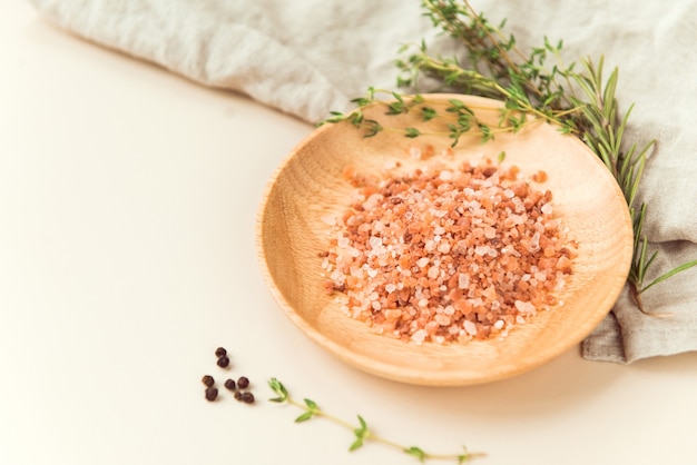 himalayan pink salt granules wooden dish and thyme