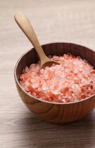 Himalayan pink salt in wooden cup on wooden table