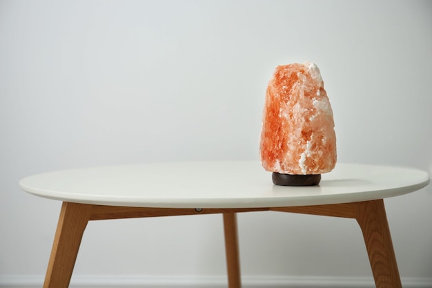 Photo himalayan salt lamp on table against light background