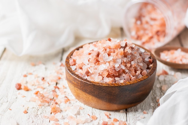 Himalayan salt or pink salt is placed in a cup on a white table