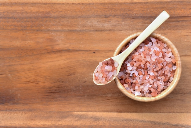 Himalayan salt Placed on a spoon and in a bowl on wood background