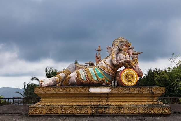 Hindu and Buddhist deity Ganesha statue as man with elephant head on high pedestal Samui Thailand