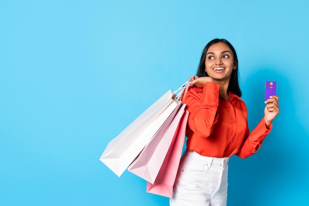 Hindu customer lady holding credit card and shopper bags studio