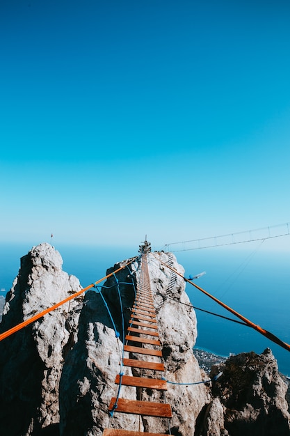 クリミア半島の山々の高いところにある蝶番を付けられた橋。背景の海縦の写真