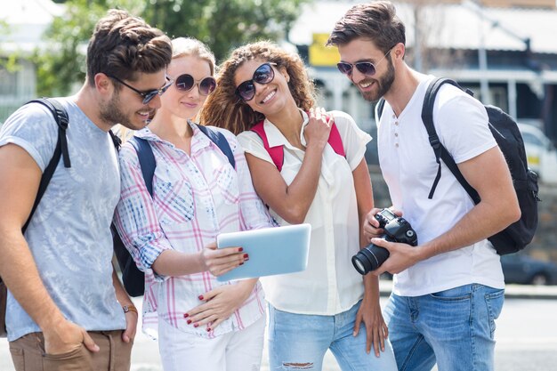 Hip friends looking at tablet on the street