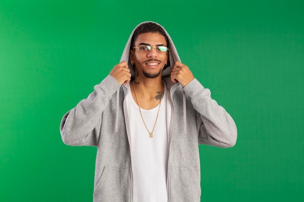 Hip hop style young adult in studio photo with green background ideal for cropping