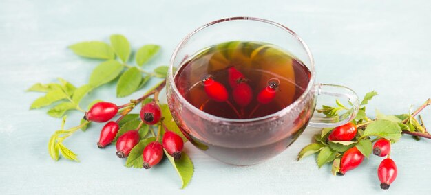 Hip rose tea with fresh fruits and leaves, hot drink in autumn and winter