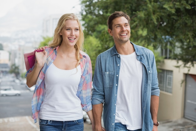 Hip young couple on shopping trip walking uphill