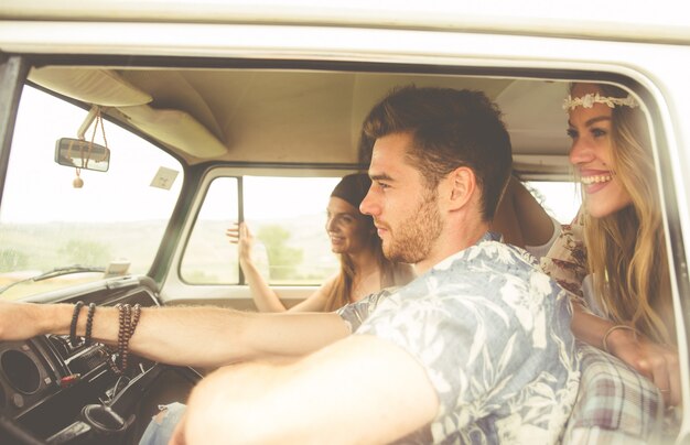 Hippie friends driving on a minivan