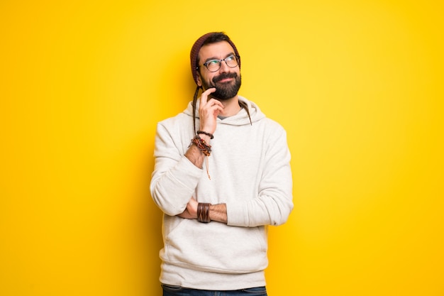 Hippiemens die met dreadlocks een idee denken terwijl het krassen van hoofd