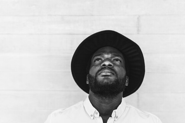 Hipster african man looking up in front of camera outdoor - Focus on face