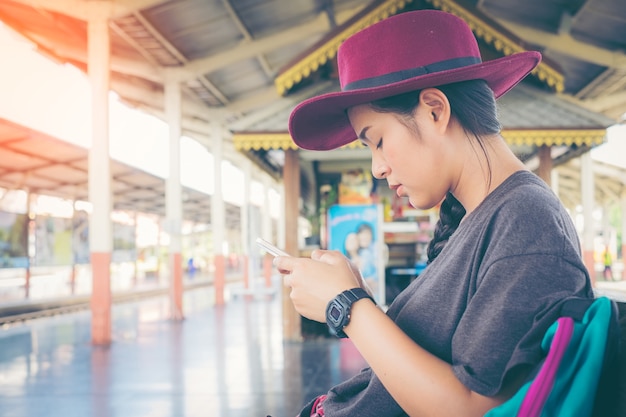 Hipster Asian tourist girl leaning on a wooden chair