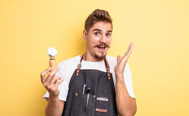 Hipster barber man feeling happy and astonished at something unbelievable