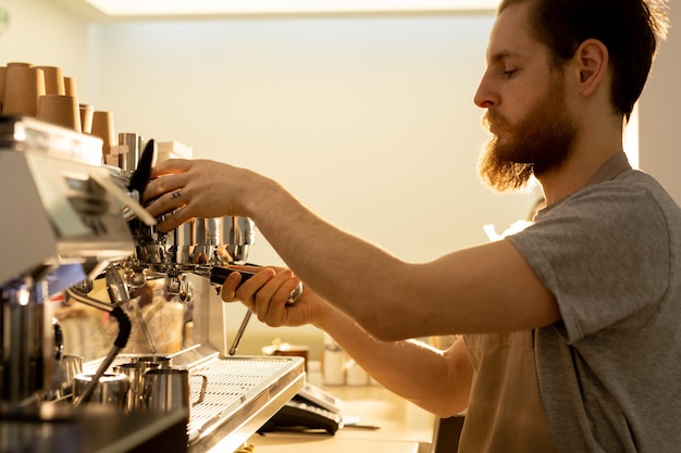 Hipster-barista die espresso voorbereidt