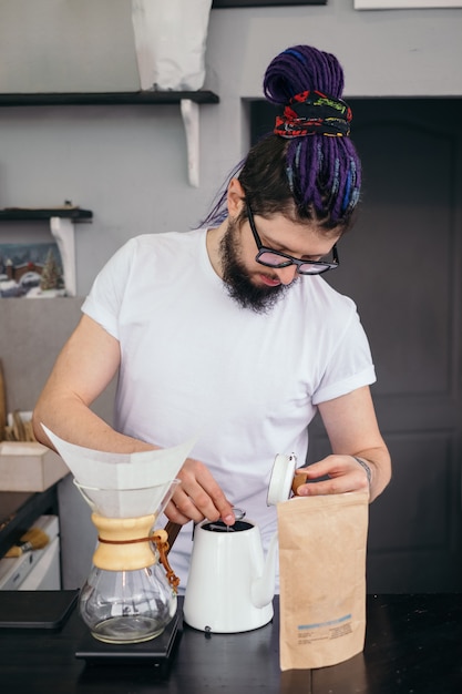 Uomo di barista hipster che produce caffè alternativo