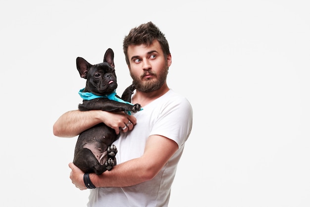 Hipster бородатый парень с любовью обнимает и обнимает красивую собаку французского бульдога и играет с ним
