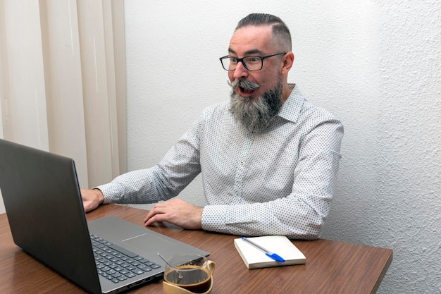 Hipster bearded man working with laptop computer at home