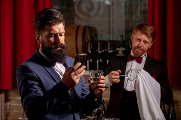 Hipster bij bar barman alcohol drinken oude traditionele whisky drinken barman bij balie