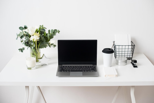Hipster bloggers werkplek laptop en bloemen op wit tafelblad