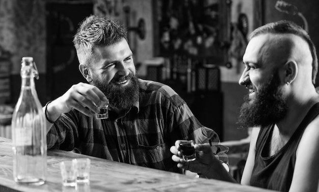 Hipster brutale bebaarde man brengt vrije tijd door met vriend aan toog Mannen ontspannen aan bar Sterke alcoholische dranken Vrijdag ontspanning in bar Vrienden ontspannen in bar of pub Soulmates dronken gesprek