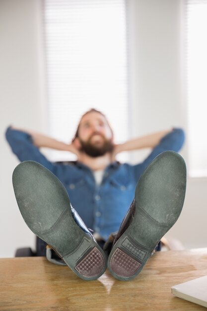 Foto uomo d'affari hipster rilassante alla sua scrivania