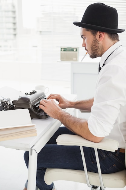 Uomo d'affari hipster con una macchina da scrivere