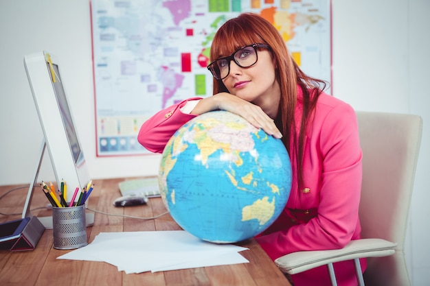 Hipster businesswoman lean on a globe