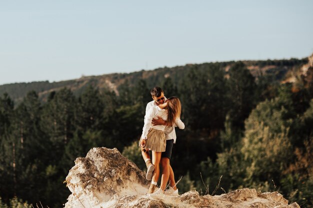 Photo hipster couple are hugging on mountain