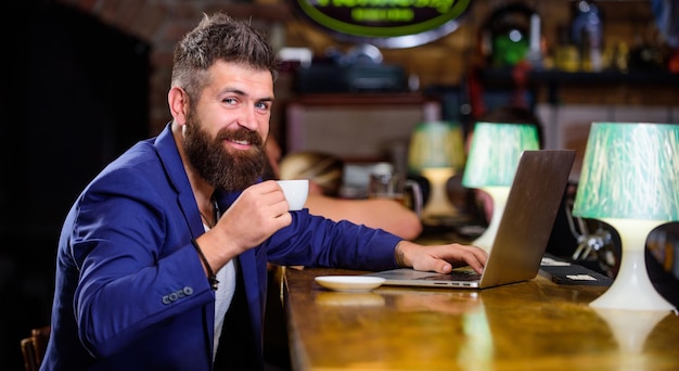 Hipster freelancer werk online blog notebook surfen op internet man bebaarde zakenman zitten pub met laptop en kopje koffie freelance voordeel manager online werken terwijl u geniet van koffie online baan