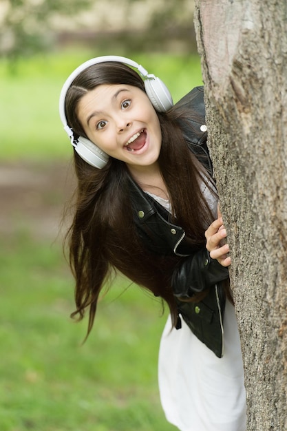 Hipster girl listening music modern headphones nature background, play with me concept.