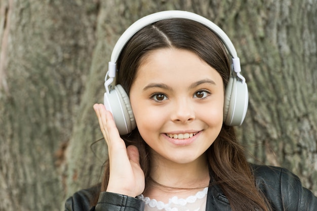 Hipster girl listening music modern headphones nature background, skip track concept.