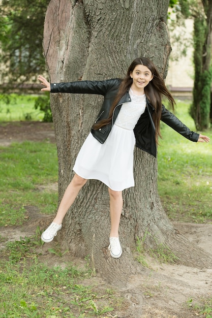 Hipster girl relaxing park tree trunk crust background, having fun concept.