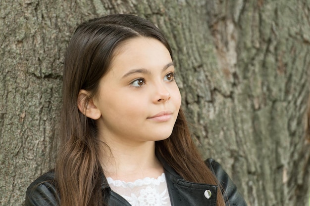 Hipster girl relaxing park tree trunk crust background thoughtful child concept