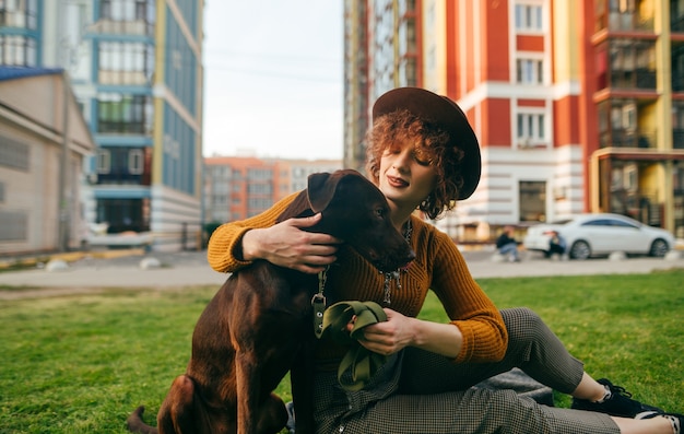 Hipster girl sitting on grass with puppy