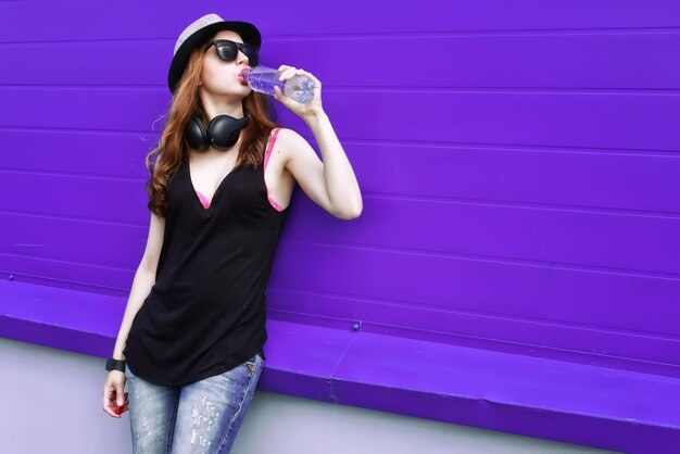 Hipster girl with headphones at the wall