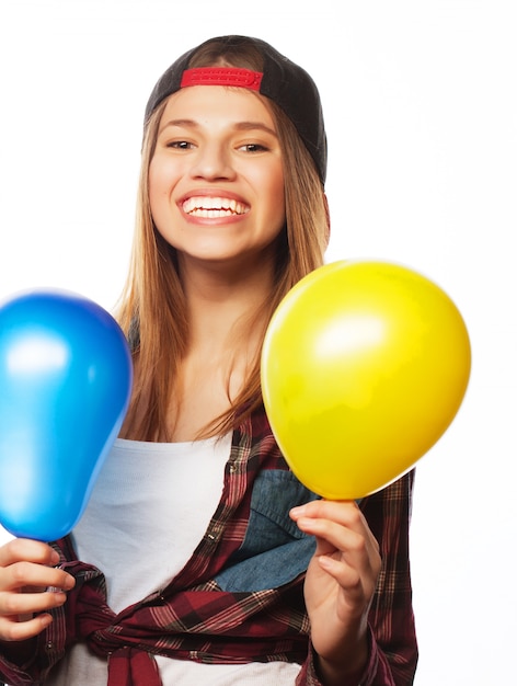 Hipster girls smiling and holding colored balloons